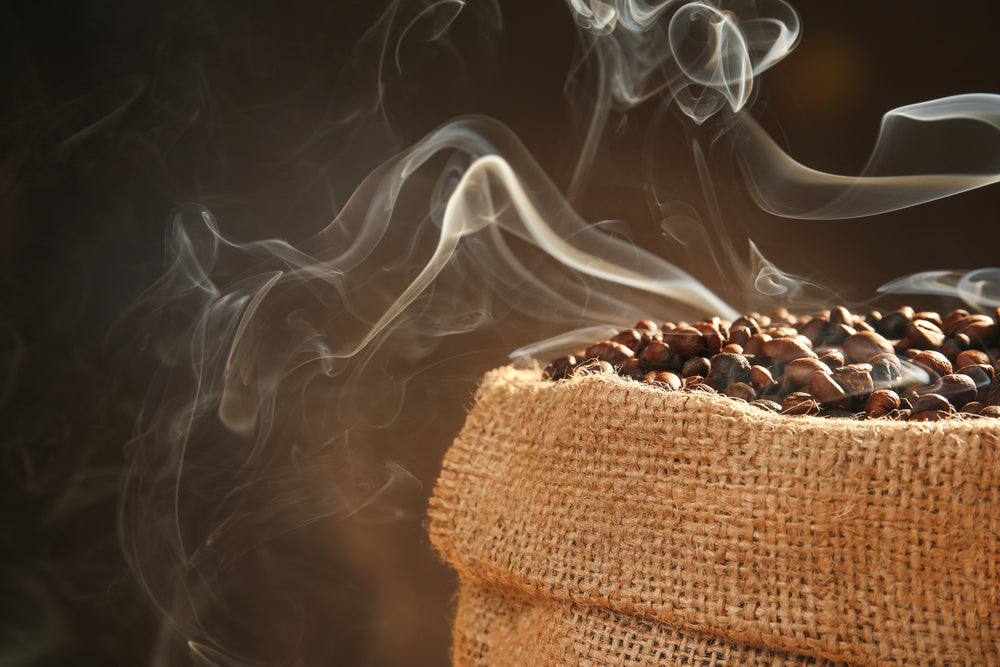 Sack of mocha java roasted coffee beans on dark background, close up view.