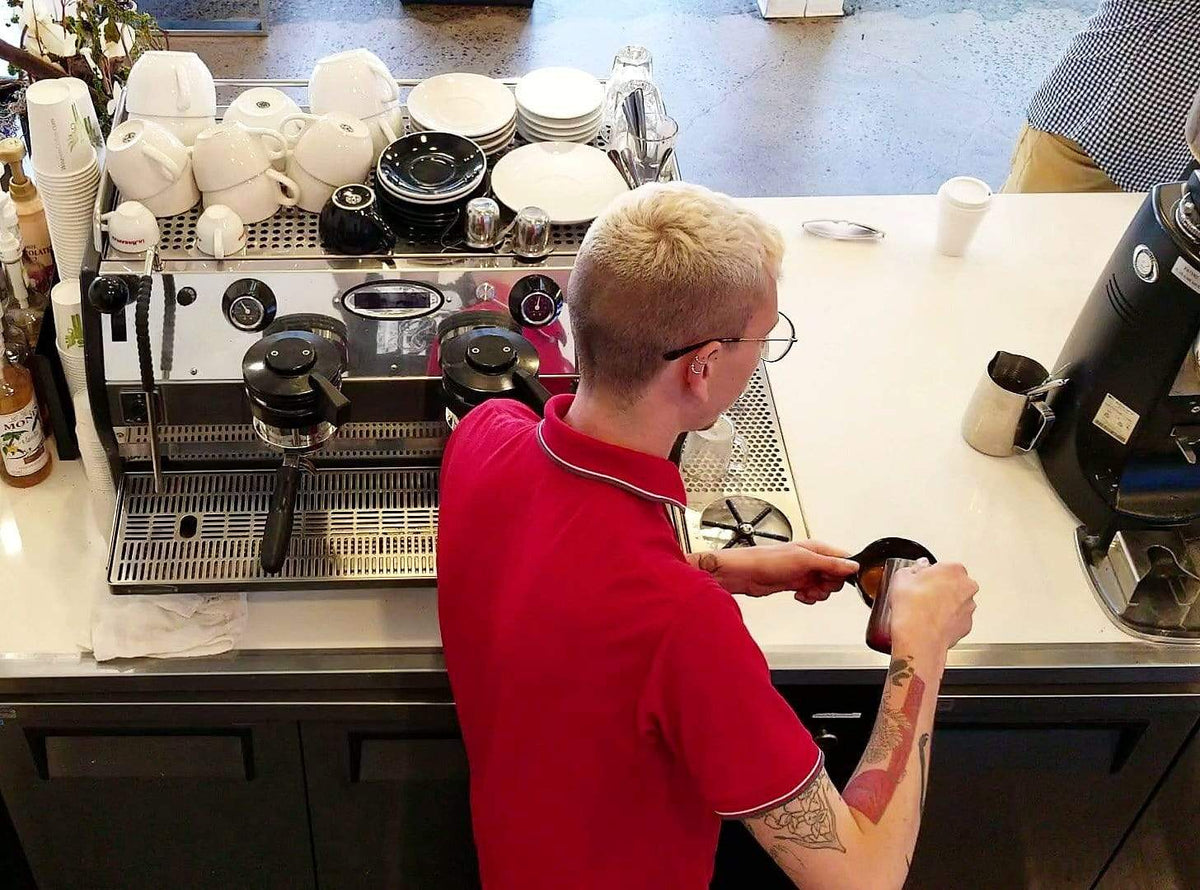 weaverscoffee.mom Barista in red shirt makes Espresso Coffee drink.